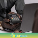 african businessman holding a pos device to a customer