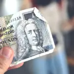a person holding a bank note in their hand