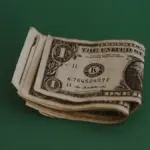 a stack of money sitting on top of a green table